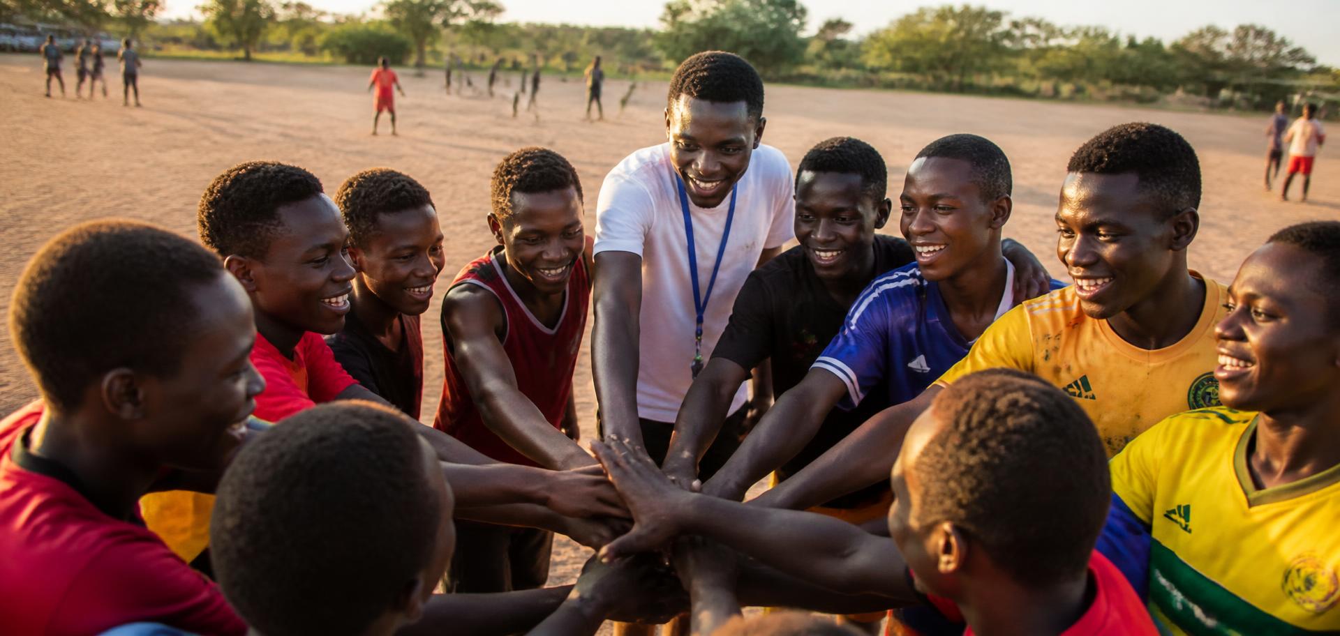 Boys in a team-building huddle during a leadership activity